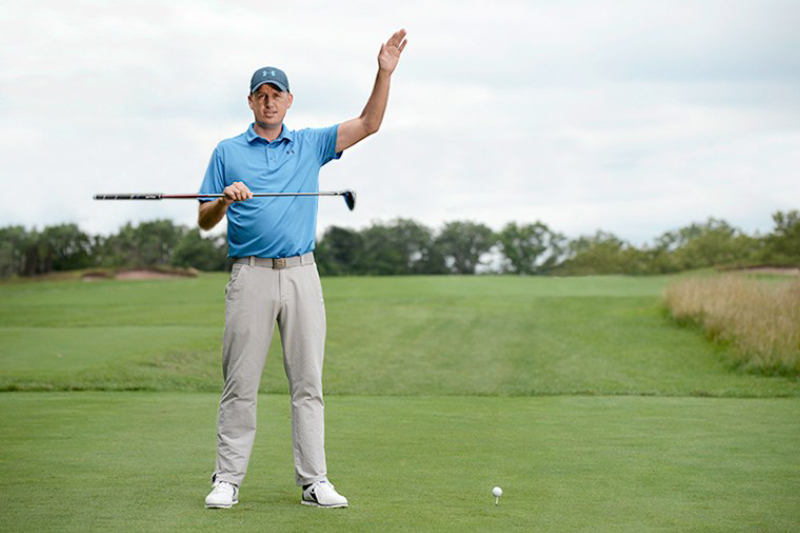 Image of a professional golfer with golf club and ball.