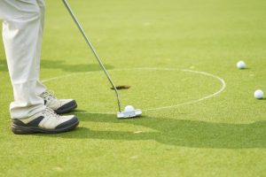 Golfer putting ball on the green golf.