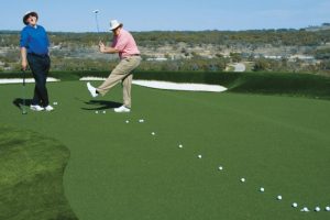 A Man practicing golf on a sunny day.