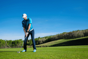 A Man practicing golf.